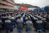 Prisioneiros na China assistem a programações que visam sua doutrinação ao sistema comunista. (Foto: BBC)