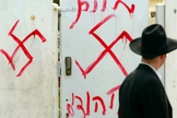 Homem judeu olha para grafite antissemita no portão de uma sinagoga próxima a Tel Aviv, em 2006. (Foto: Uriel Sinai/Getty Images)