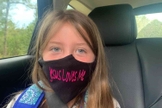 Lydia Booth foi proibida de usar sua máscara com a inscrição "Jesus Loves Me" ("Jesus me Ama") e agora sua família está processando a escola onde ela cursa a 3ª série. (Foto: Alliance Defending Freedom)