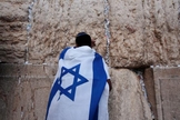 Jovem durante oração no Muro das Lamentações, coberto com a bandeira de Israel. (Foto: Reuters/Darren Whiteside)