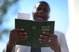 Pastor lê a Bíblia enquanto conduz uma oração, nos EUA. (Foto: Joe Raedle/Getty Images)