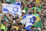 Brasileiros seguram a bandeira de Israel. (Foto: Silvia Izquierdo/AP)