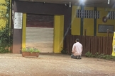 Ademir ajoelhado em frente a sua padaria em SP. (Foto: Reprodução/Facebook/Juliana Balbi)