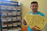 Detento com mostra as histórias que escreveu em sua coletânea. (Foto: Divulgação/Sejus)