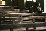 Cristão lê Bíblia sozinho no banco de uma igreja em, Kano, Nigéria. (Foto: Getty Images/Chris Hondros)