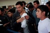 Imigrantes ilegais aguardam enquanto recebem seus pertences e processam sua volta ao aeroporte de La Aurora (Guatemala), de onde saíram.