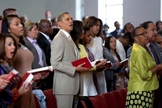 Na imagem, Barack Obama aparece junto à sua família, participando de um culto em meio a outros fiéis.