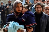 Pessoas fazem fila para receber ajuda humanitária no campo de refugiados palestinos.