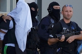 Com a cabeça coberta por uma camisa, Yassin Salhi é levado pela polícia francesa
