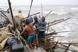 Uma família que vive na baía de Manila tenta achar pertences que possam ser recuperados, após a sua casa ter sido destruída por fortes ventos trazidos pelo tufão Koppu neste domingo, 18/10. (Foto: Romeo Ranoco/Reuters)