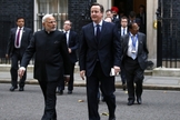 Primeiro-ministro Modi caminha ao lado de David Cameron, e meio a protestos de manifestantes enfurecidos (Foto: Reuters)