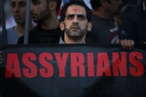 Um homem assírio caminha durante um protesto unido a centenas de pessoas. (Foto: Reprodução/The Wall Street Journal)