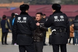 Policiais interrogam um homem na Praça Tiananmen, em Pequim. (Foto: Greg Baker/Agence France-Presse — Getty Images)