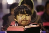 Criança lê Bíblia em igreja no vilarejo de Gaojiabao, na China. (Foto: Jason Lee/Reuters)