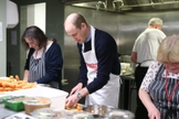 Príncipe William prepara almoço na instituição A Passagem, que apoia sem-teto em Londres. (Foto: Divulgação/Premier)