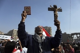 Manifestante egípcio segura uma cruz e um Alcorão em protesto na Praça Tahrir, no Cairo, Egito. (Foto: AP/Khalil Hamra)