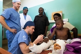 Médicos cuidam de Amié, de 9 anos, depois de uma cirurgia extensa em suas pernas. (Foto: David K. Morrison/Samaritan's Purse)