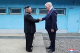 Trump em aperto de mãos com Kim na linha de demarcação que divide as duas Coreias. (Foto: KCNA via Reuters)