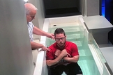 Pastor Mike Lefler (à esquerda) se prepara para batizar Brenton Winn durante um culto. (Foto: Central Baptist Church)