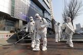 Trabalhadores com equipamento protetor usam desinfetante em spray contra o novo coronavírus em frente à igreja em Daegu, na Coreia do Sul, nesta quinta-feira (20). (Foto: Kim Jun-beom/Yonhap via AP)