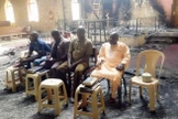Os anciãos da igreja nigeriana realizam o culto de domingo em meio às cinzas de sua igreja incendiada apenas dois dias após um devastador ataque ao Boko Haram. (Foto: Reprodução / Barnabas)