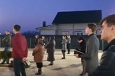 Membros da Igreja Cristã após o Evangelho de Sião, na vila de Prelipca, reunidos no estacionamento. (Foto: Reprodução/YouTube)