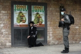 Policial israelense detém um judeu ultraortodoxo durante patrulha em Jerusalém. (Foto: Reprodução/AFP)