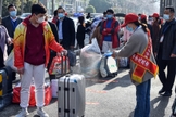 Voluntária aplica desinfetante sobre a bagagem de um aluno em Bozhou, na província de Anhui, no leste da China. (Foto: AFP)