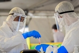 Médicos manuseiam uma amostra de teste de coronavírus em Tel Aviv. (Foto: Flash90) 