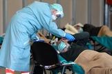 Equipe médica ajuda pacientes dentro do hospital Spedali Civili em Brescia, na Itália. (Foto: Flavio Lo Salzo/Reuters)