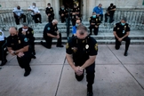 Policiais se ajoelharam durante um comício em Coral Gables, Flórida, no sábado, em resposta à morte de George Flay. (Foto: Eva Marie Uzcategui / AFP via Getty Images)