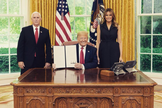 Donald Trump exibe a assinatura da ordem, entre a primeira-dama Melania e o vice Mike Pence. (Foto: Reprodução/Twitter)