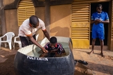 Pastor de Burkinabé, Bonogo Fulgence, batiza dois caminhoneiros em Ouagadougou, Burkina. (Foto: Reprodução / IMB)