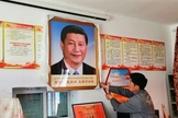 Homem pendura um retrato do presidente chinês Xi Jinping, no condado de Dzoge, no leste do Tibete. (Foto: Free Tibet)