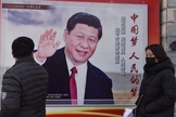 Pessoas passam por um pôster do presidente chinês Xi Jinping ao lado de uma rua em Pequim. O controle cada vez maior de Xi Jinping sobre a China já rendeu ao líder comparações com Mao Tsé Tung. (Foto: AFP / GREG BAKER)