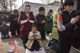 Cristãos chineses oram ajoelhados durante um culto de Páscoa em uma igreja não oficial. (Foto: Getty Images / Kevin Frayer)