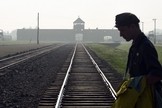 Homem atravessa trilhos do antigo campo de concentração de Auschwitz, na Polônia. (Foto: AP/Alik Keplicz)