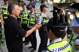 O Pr. Eric Foley conversa com policiais sul-coreanos; em destaque balões sento soltos. (Foto: Voice of the Martyrs Korea)