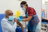 O trabalhador de uma casa de repouso, Pillary Jagambrun, de 61 anos, recebe dose da vacina da Pfizer-BioNTech contra de Covid-19 no Hospital da Universidade Croydon, no sul de Londres, na terça-feira. (Foto: PA)