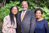 Pastor Eli Henry (ao centro), com sua esposa (à esquerda) e sua filha, Irma (à direita). (Foto: IASD News)