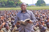 O pastor Samuel Kasigwa compartilha o Evangelho na véspera de Ano Novo com milhares de recrutas da Polícia em treinamento em Kabalye. (Foto: Reprodução / UGCN)