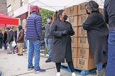 A voluntária Gloria Martinez, à esquerda, fala com Sofia Moncayo, que dirige um programa de distribuição de alimentos por meio da Mosaic West Queens Church. (Foto: Emily Leshner / AP)