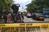 Policiais montam guarda ao longo de uma rua fechada após explosão em frente a igreja, na Indonésia. (Foto: Antara Foto/Arnas Padda via Reuters)