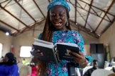 Mulher e a Bíblia Pidgin durante culto na Igreja do Cidadão Celestial em Lagos, Nigéria. (Foto: Reuters / Temilade Adelaja)