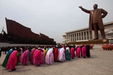 Norte-coreanos prestam reverência a uma estátua de Kim Il-Sung, que criou sua própria religião em Pyongyang. (Foto: David Gittenfelder/AP/Veja)