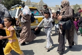 Mães e filhos tentam entrar no aeroporto Hamid Karzai, em Cabul, para fugir do país. (Foto: Reuters)