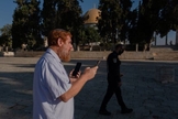 O rabino Yehudah Glick orando no Monte do Templo, em agosto de 2021, enquanto um policial patrulhava nas proximidades. (Foto: Amit Elkayam/The New York Times).