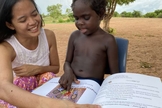 Rachel lendo o livro de sua autoria “Adotados em Amor” para uma criança Yolngu. (Foto: Reprodução/Eternity)