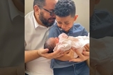 Momento em que João Prudêncio Neto e seu filho Davi recebem a pequena Giovanna nos braços. (Foto: Captura de tela/Vídeo Facebook)