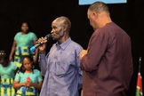 Homem conta seu testemunho após receber oração do Pr. Gerald Mwebe, no culto de Páscoa. (Reprodução / UGCN)